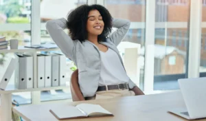 happy-business-woman-stretching-at-desk-for-relax