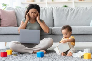 motherhood-stress-annoyed-black-mother-working-on-laptop