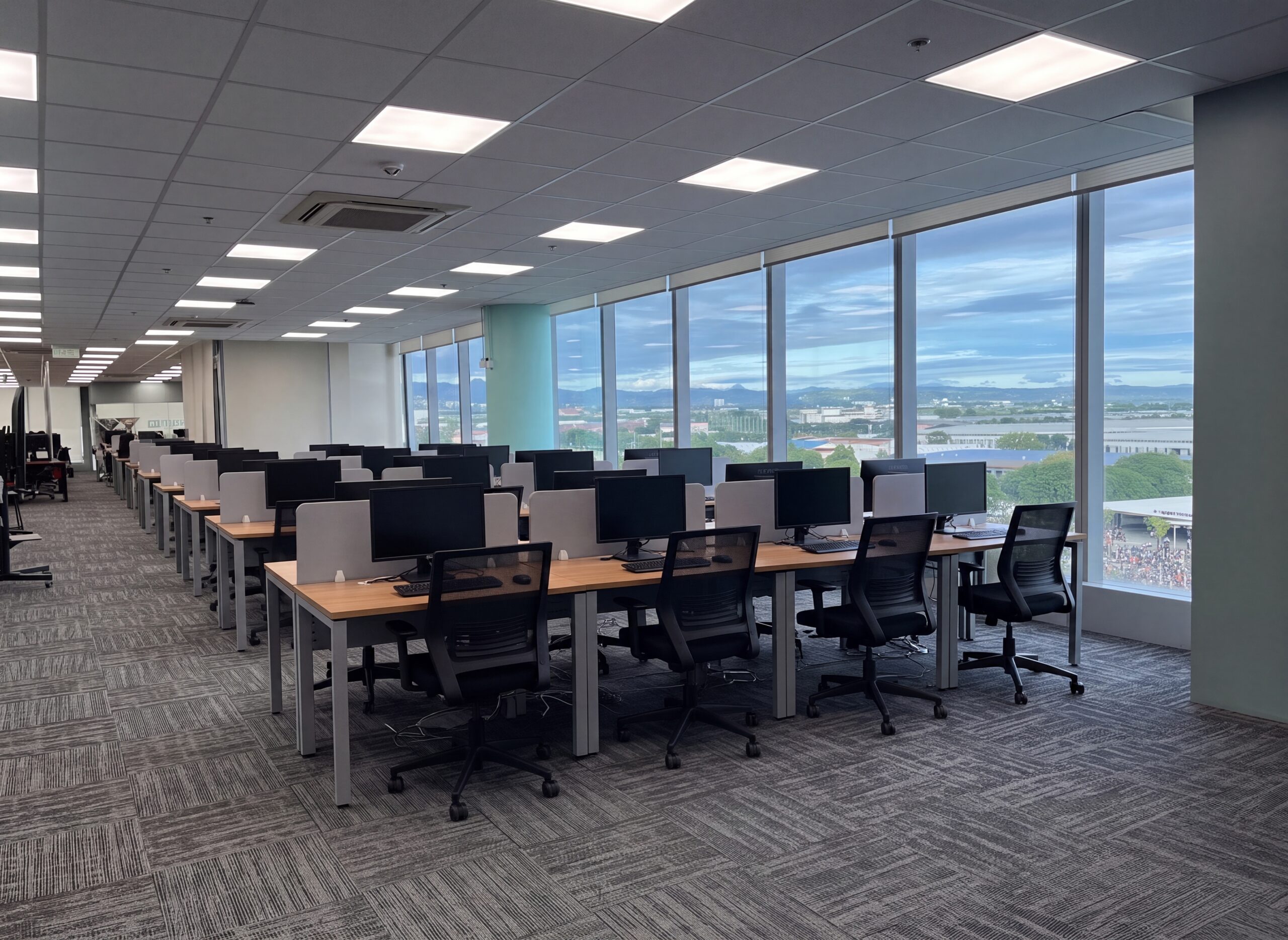 Workstations beside floor-to-ceiling windows