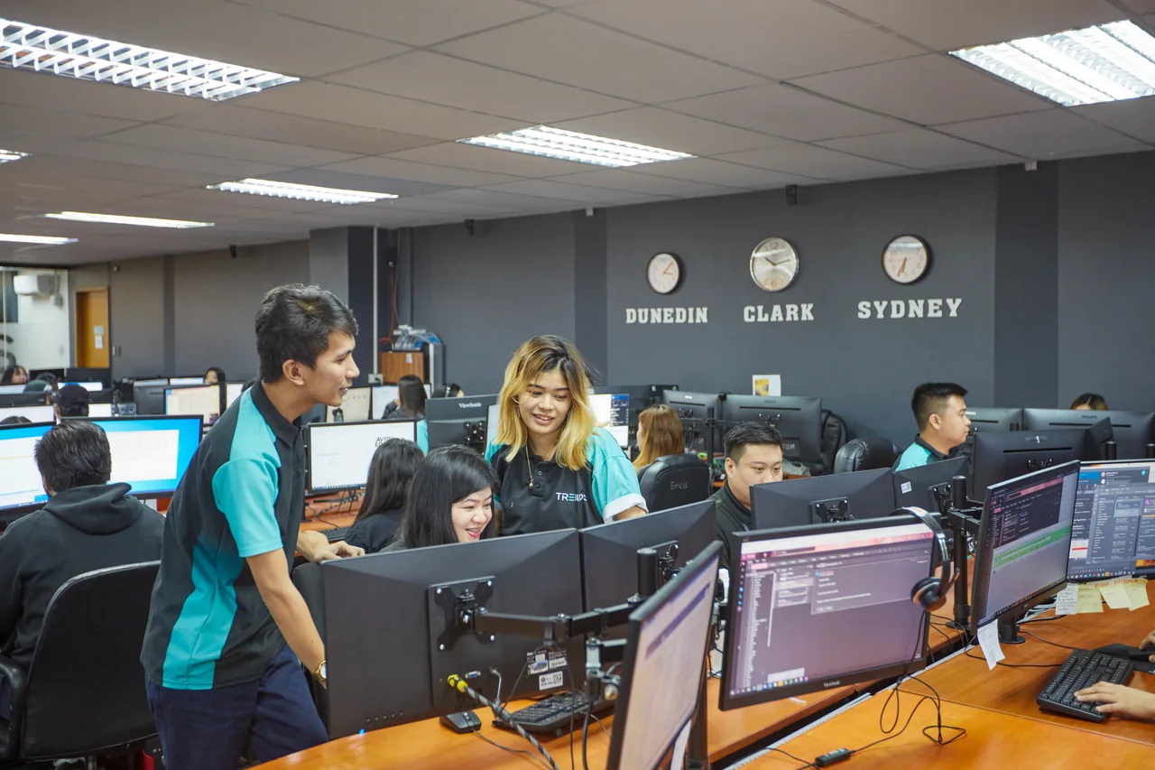 BPO contact center outsourcing in the Philippines — colleagues reviewing work together at a computer workstation
