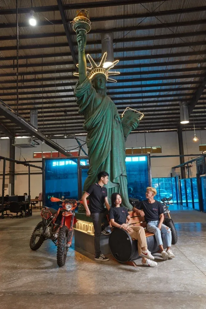 Colleagues beside the Statue of Liberty replica inside Clark Outsourcing