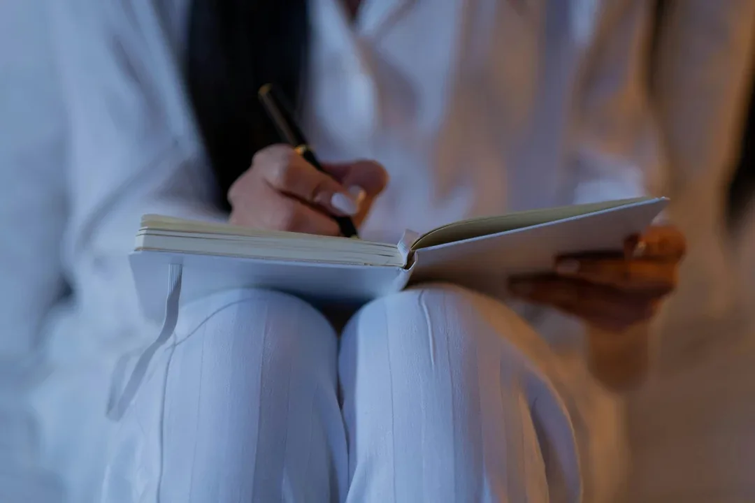Healthcare professional writing notes on a clipboard
