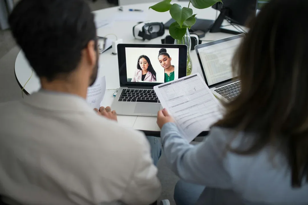 Colleagues joining a video meeting on a laptop