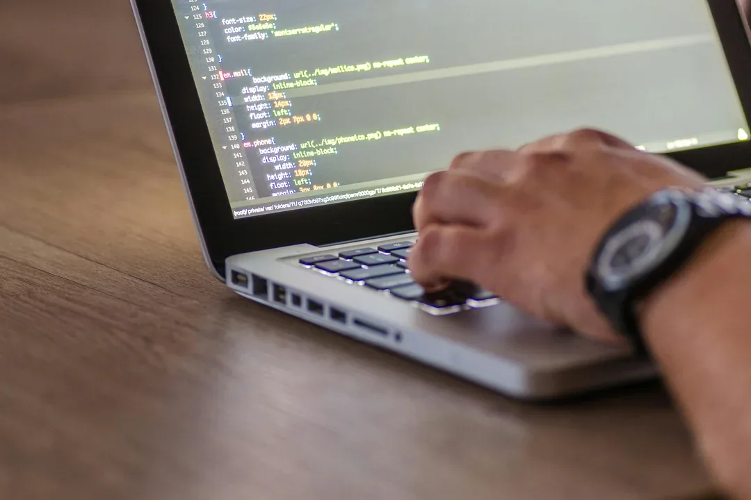 Developer working with code on a laptop