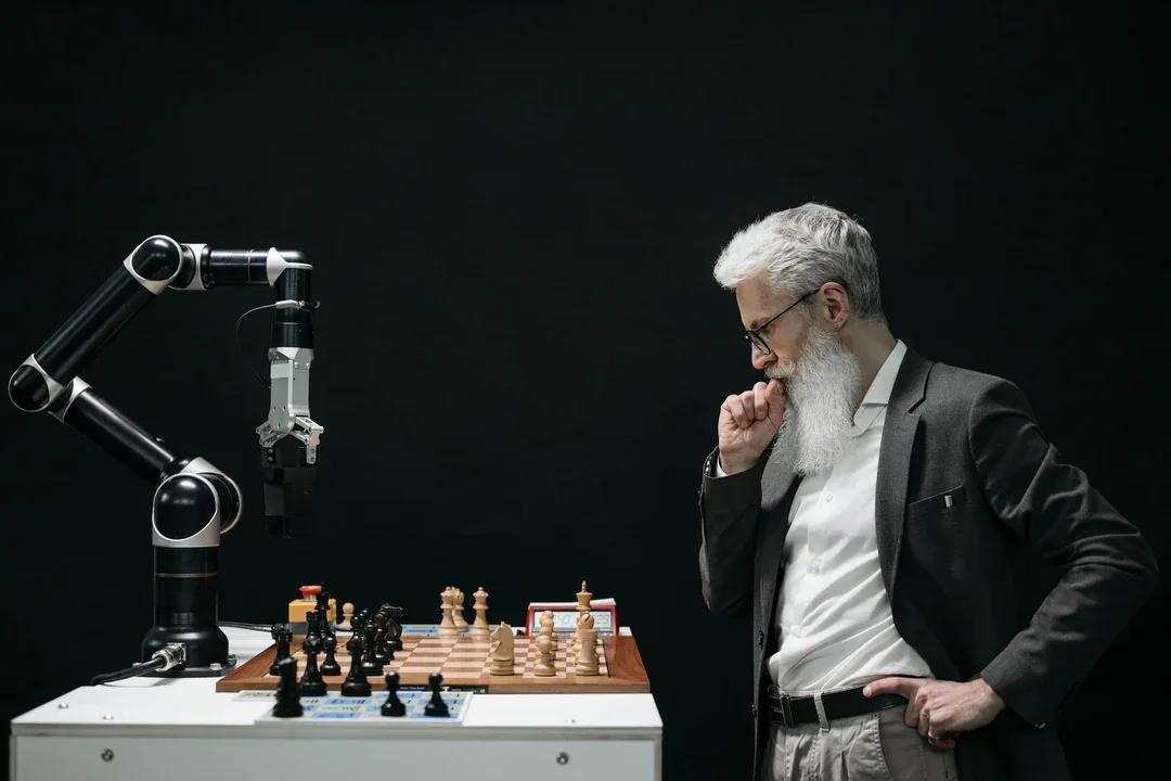 Person playing chess opposite a robotic arm