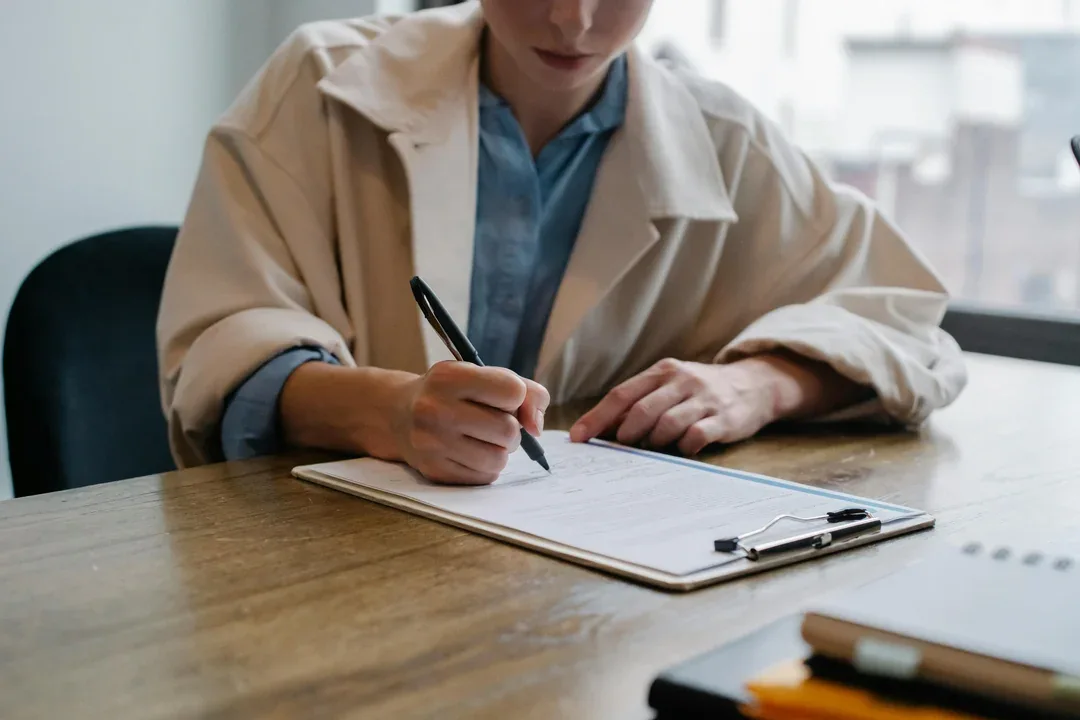 Healthcare professional writing notes on a clipboard
