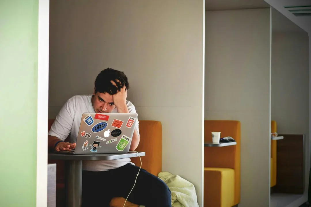 Person pausing while working on a laptop