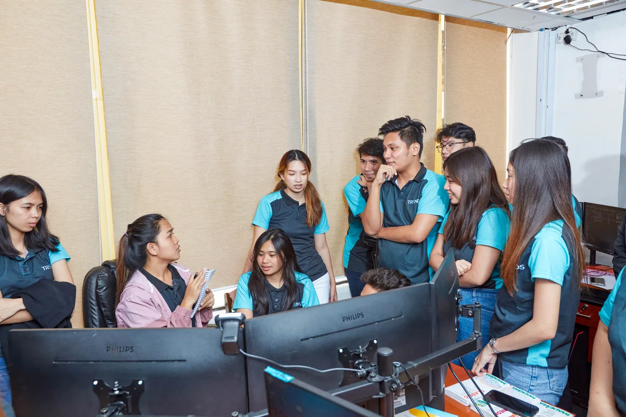 Digital media marketing outsourcing in the Philippines — colleagues gathered around computer screens for a team discussion