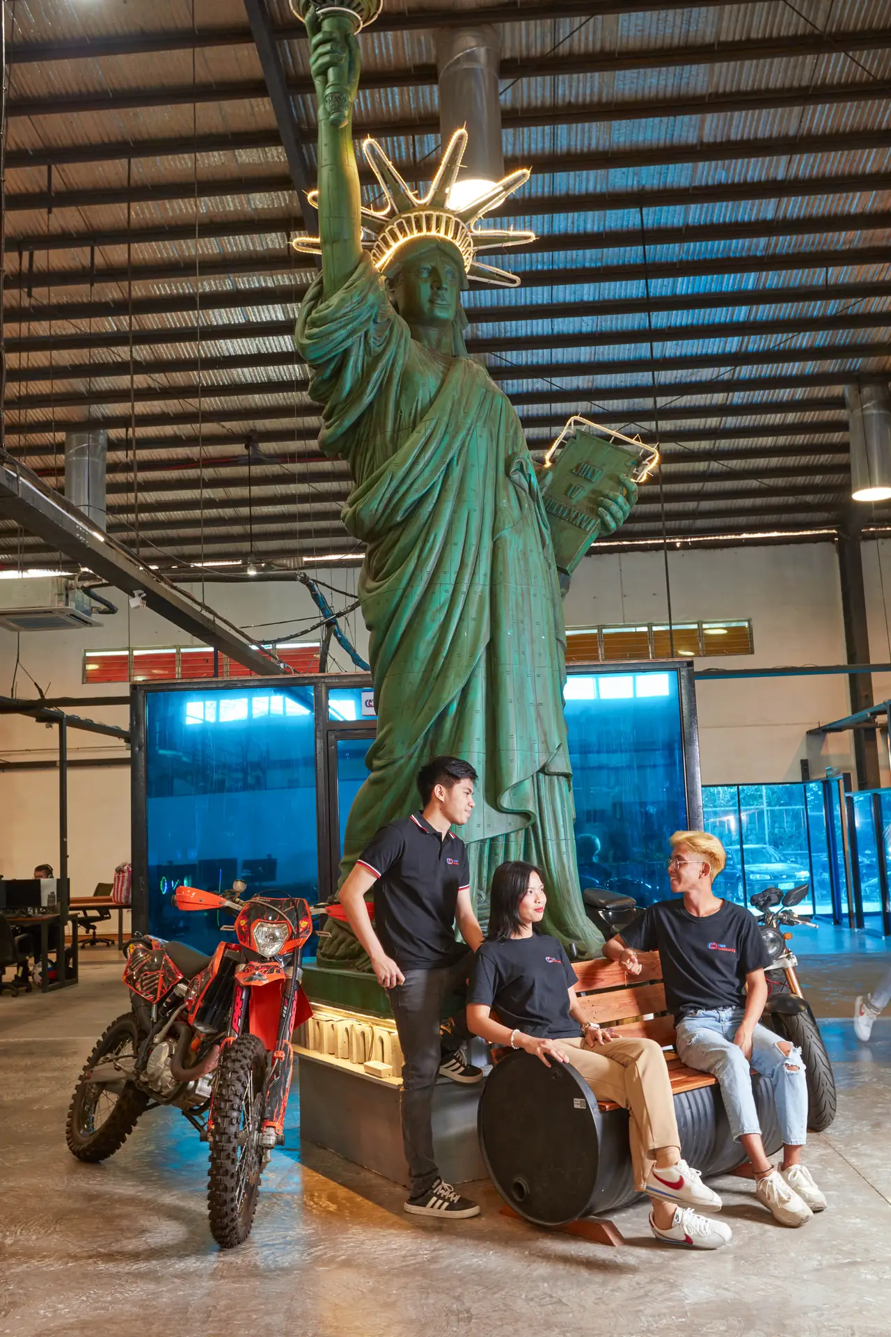 Digital media marketing outsourcing in the Philippines — colleagues seated near the large Statue of Liberty decoration in the office