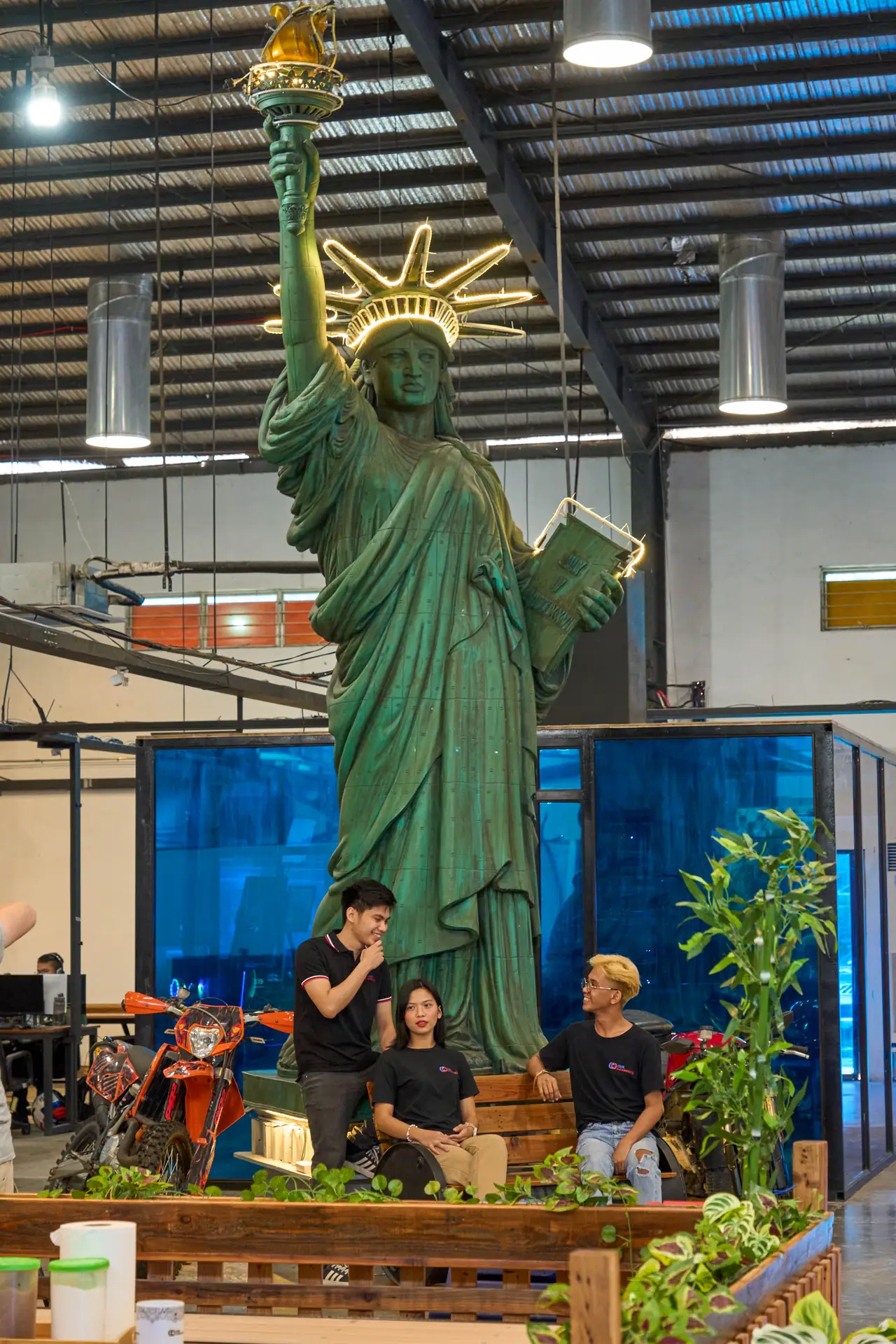 Digital media marketing outsourcing in the Philippines — colleagues talking near the large Statue of Liberty decoration in the office