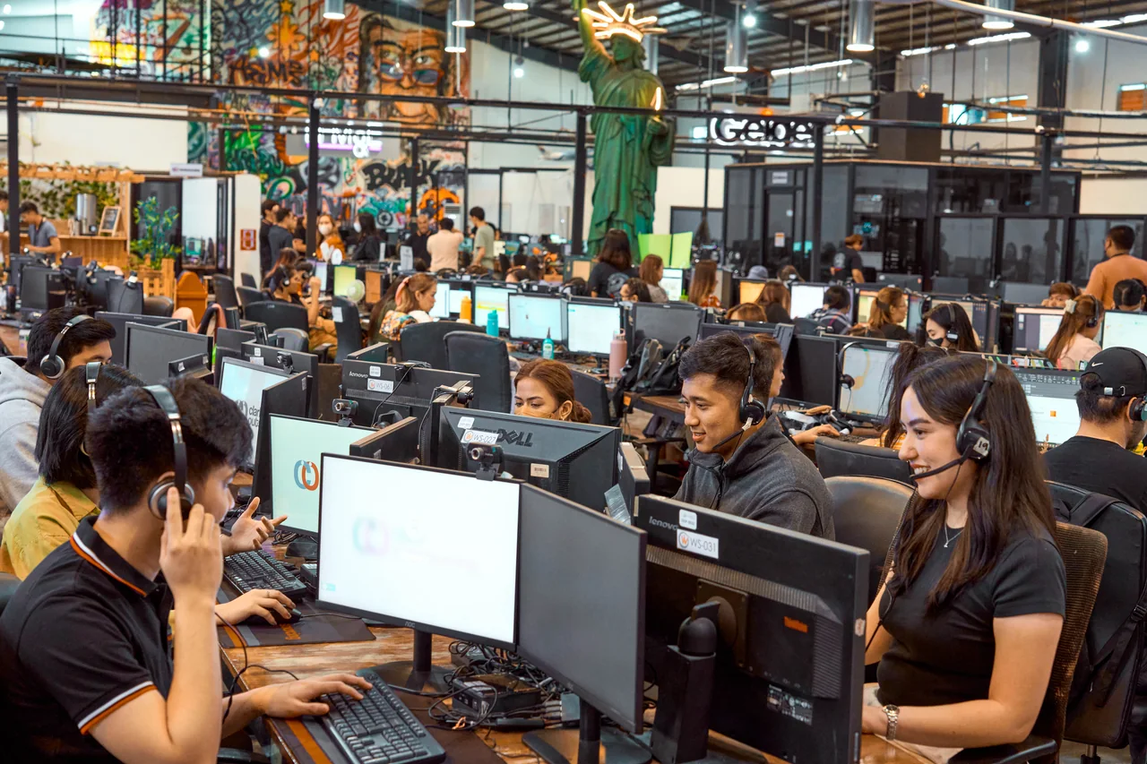 Digital Administrator outsourcing in the Philippines — headset-wearing colleagues at computer workstations in the open-plan office