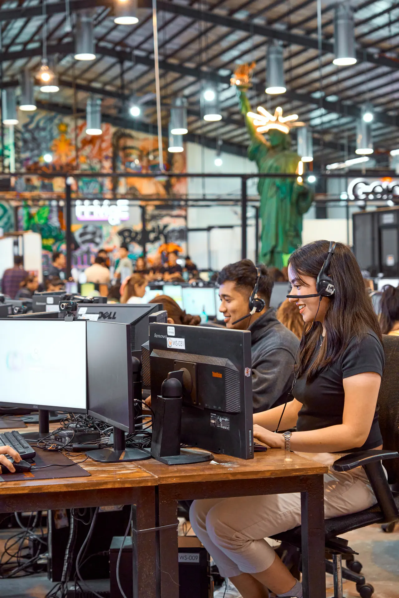 Insurance Verification Specialist outsourcing in the Philippines — team member wearing a headset at a desktop workstation in the open office