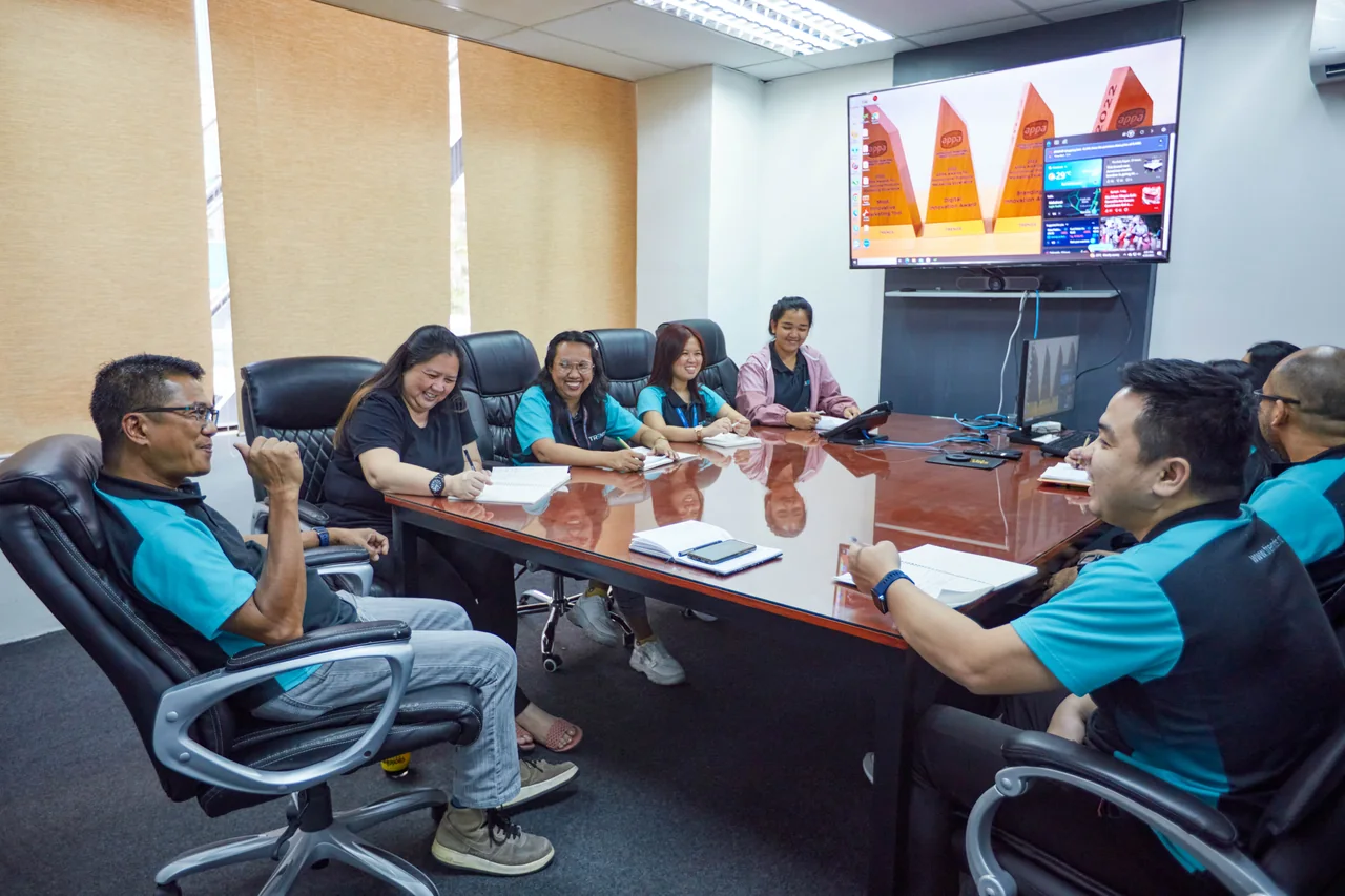 Medical Recruiter outsourcing in the Philippines — colleagues in a meeting around a conference table with notes and a wall display