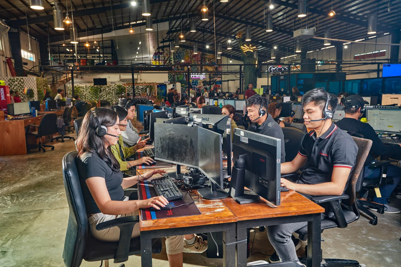 Medical Scheduler outsourcing in the Philippines — team members wearing headsets and using desktop computers in an open office
