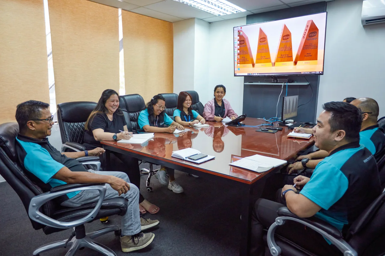 Operations Manager outsourcing in the Philippines — colleagues meeting around a conference table with documents and a wall display