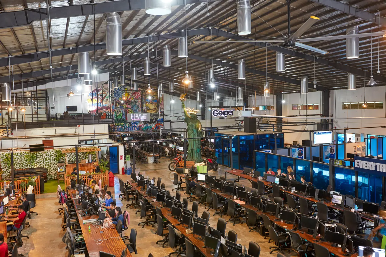 Real estate outsourcing in the Philippines — elevated wide view of the open-plan office, workstations and enclosed rooms