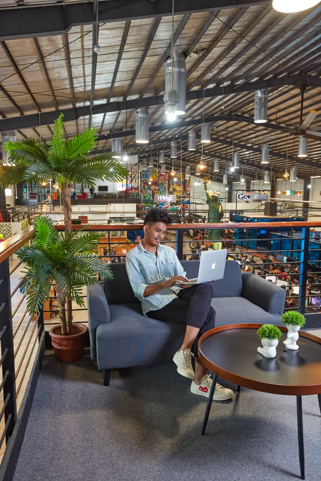 Real estate outsourcing in the Philippines — team member working on a laptop in a lounge above the open office